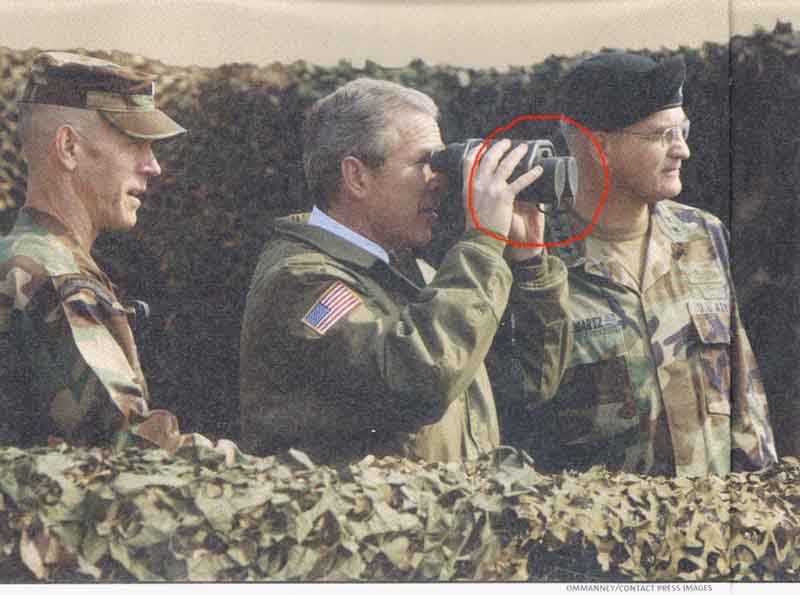 Bush looking through field glasses
with the lens covers on